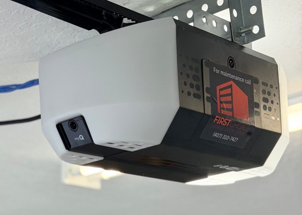 Ceiling-mounted garage door opener motor with emergency release cord installed by First Choice Garage Door Service